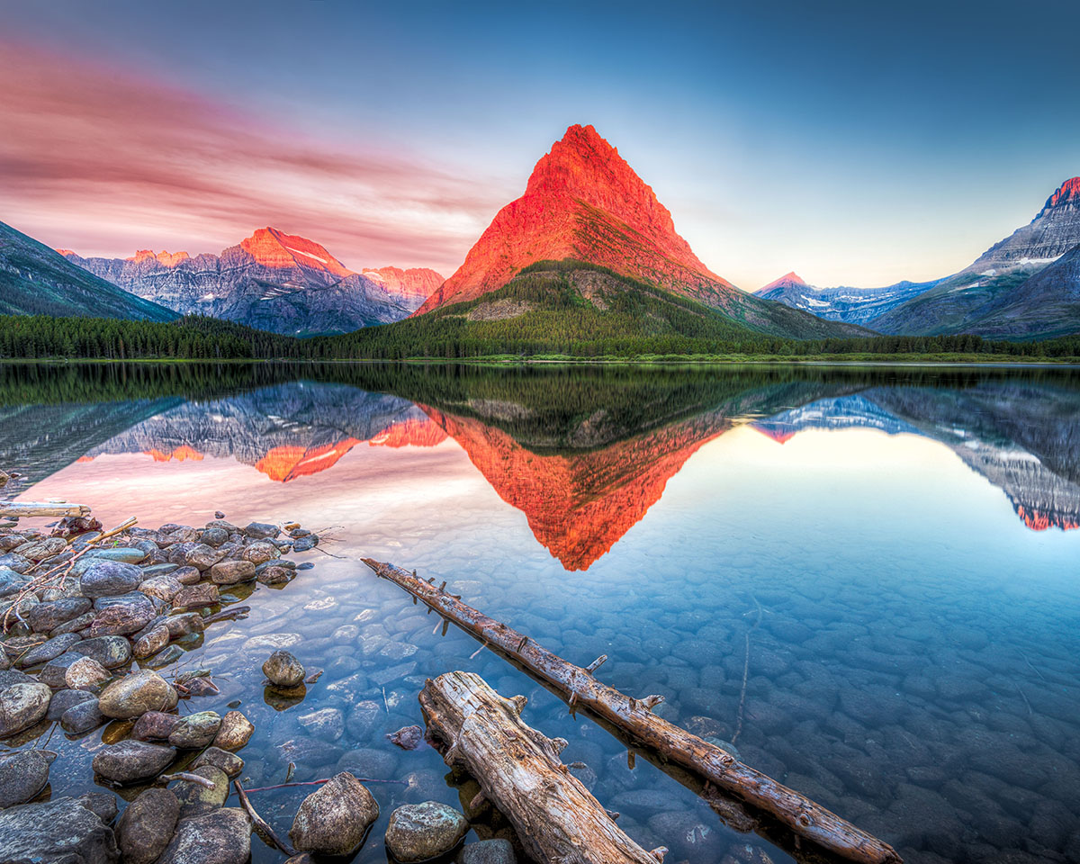 A lake surrounded by trees and mountains