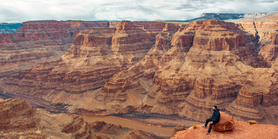 Randonneur assis sur le bord du Grand Canyon
