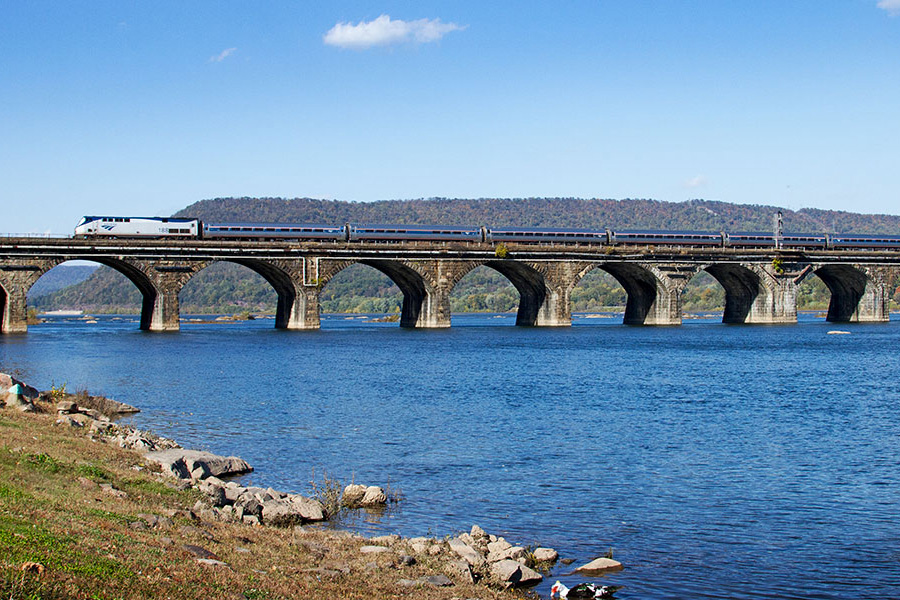 A train travels on a bridge over a river