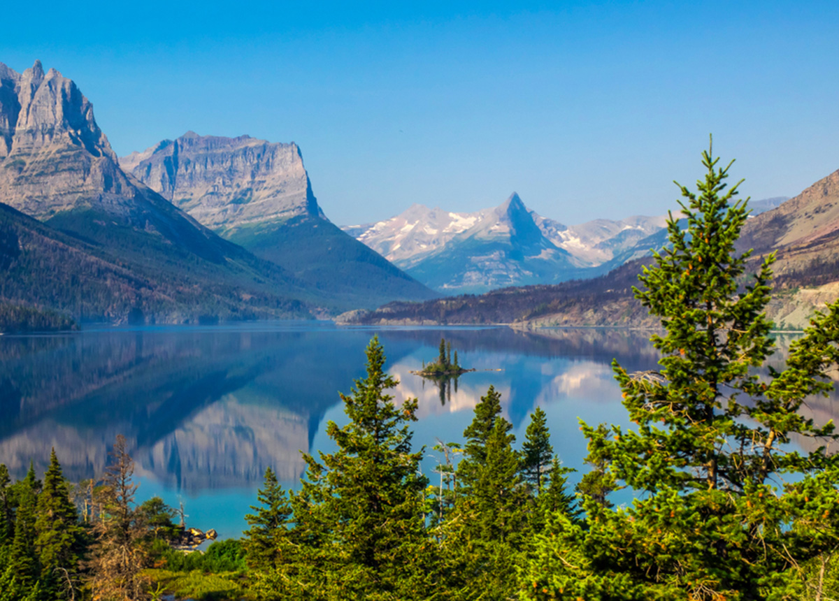 A lake surrounded by trees and mountains