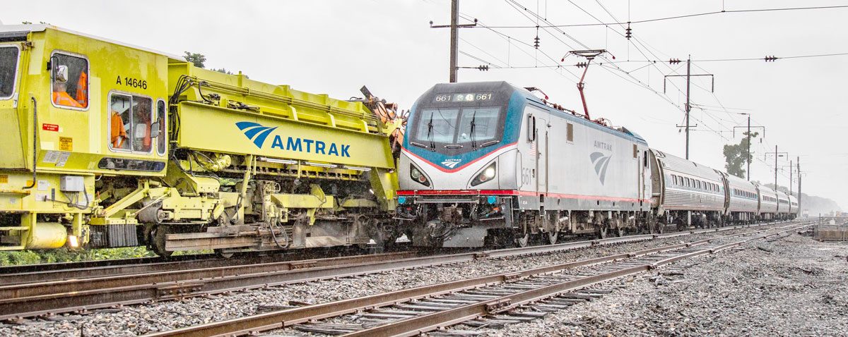Ein Amtrak-Zug, der an einer Baumaschine vorbeifährt