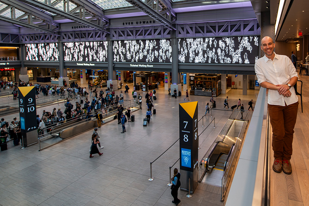 Artist Joshua Frankel overlooks his video art installation in Moynihan Train Hall