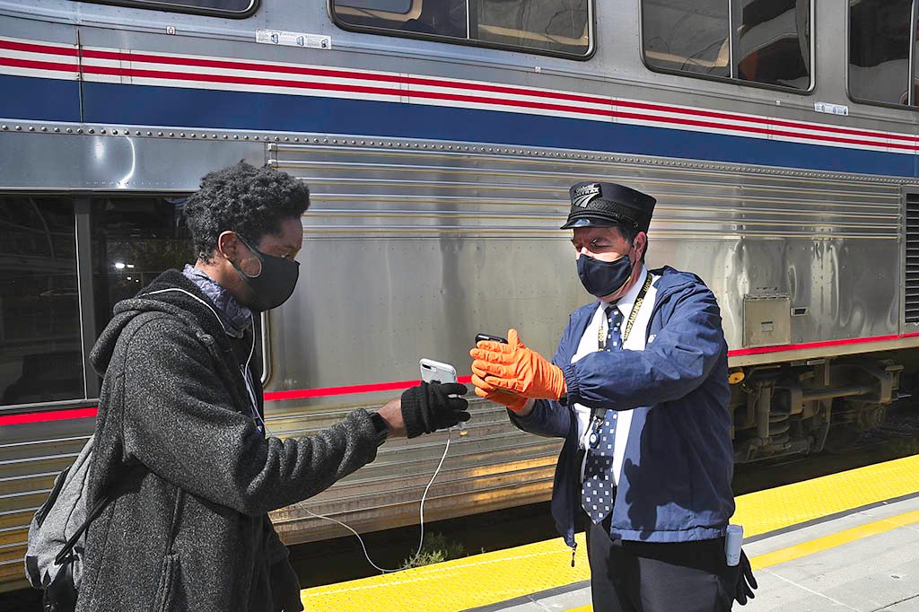 Conductor looking at a passengers mobile phone eTicket.