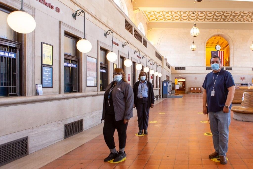 People standing in social distances in a station.