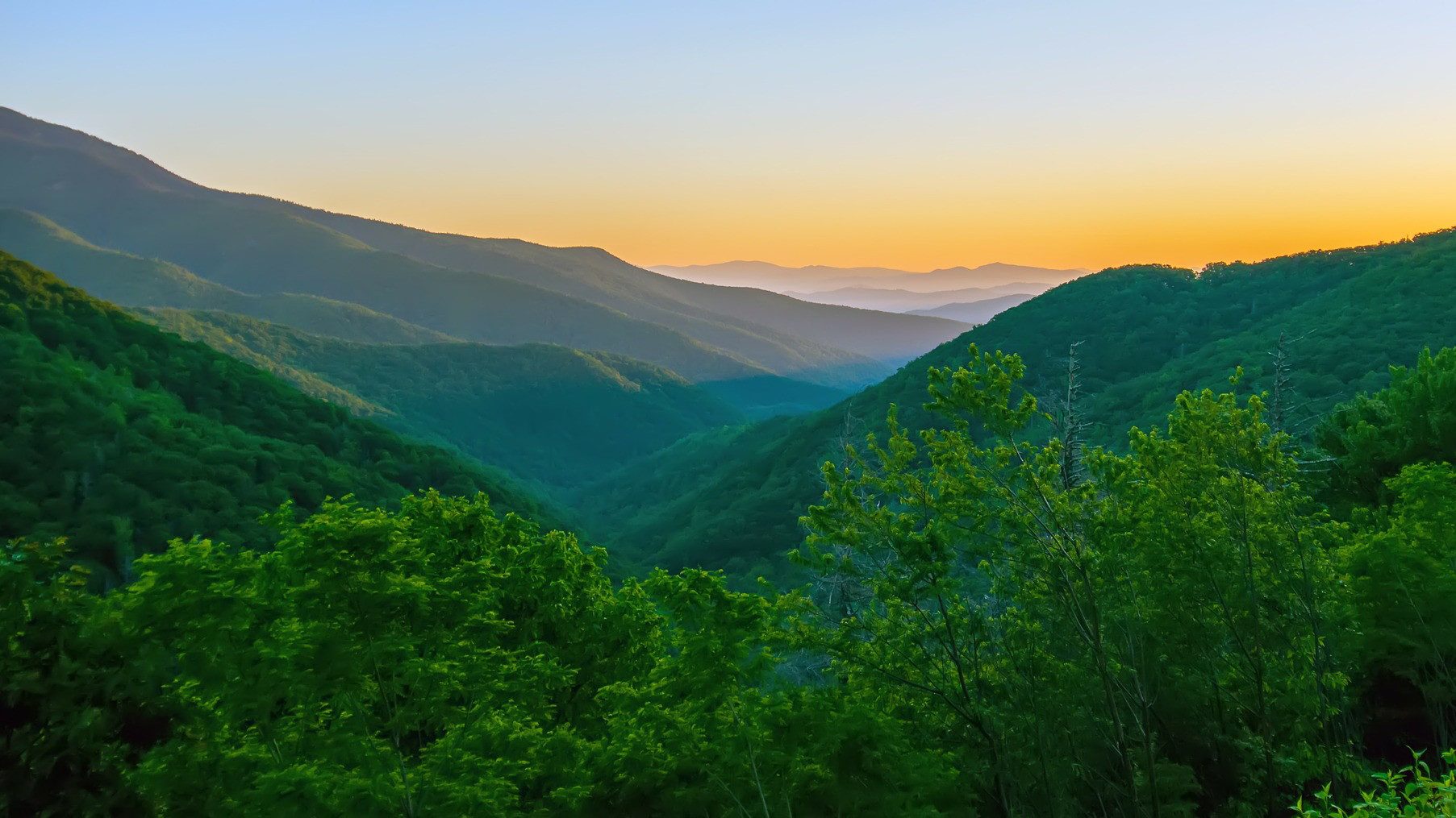 Lever de soleil au-dessus de montagnes verdoyantes