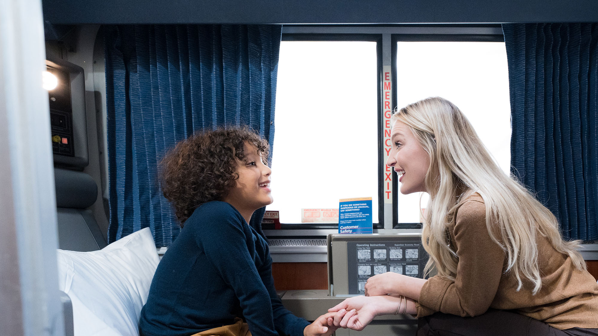 A mother and son talk to each other in a roomette