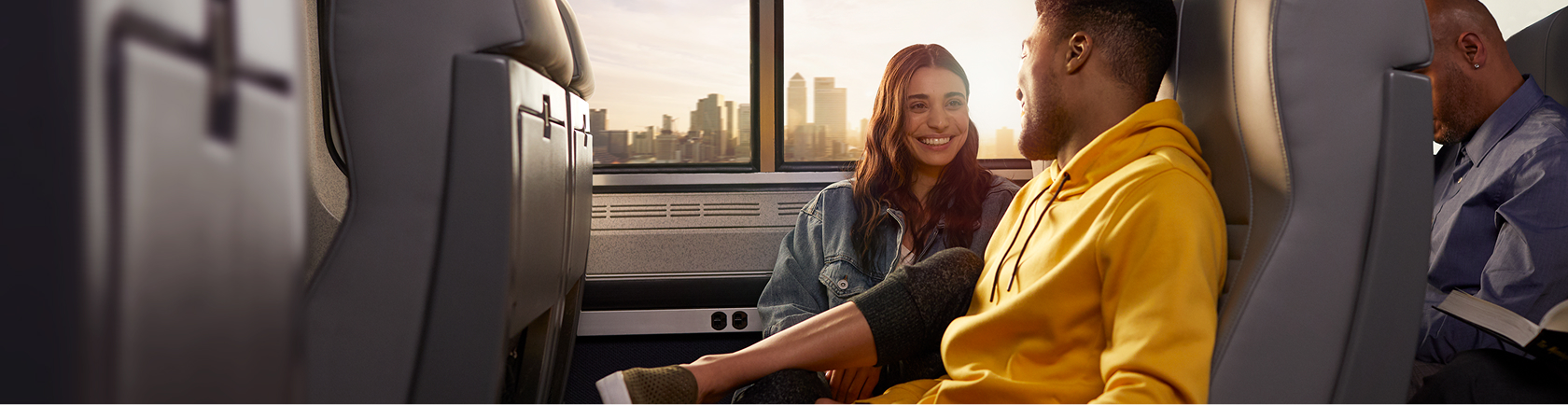 couple-seated-on-amtrak-with-a-cityscape-shown-through-the-window