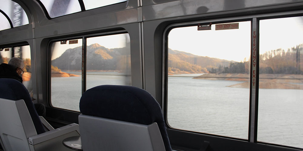 Vista del lago y los árboles desde el vagón de observación del Coast Starlight