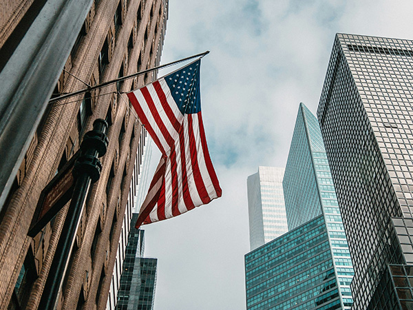 American flag on building with skyscraper backdrop