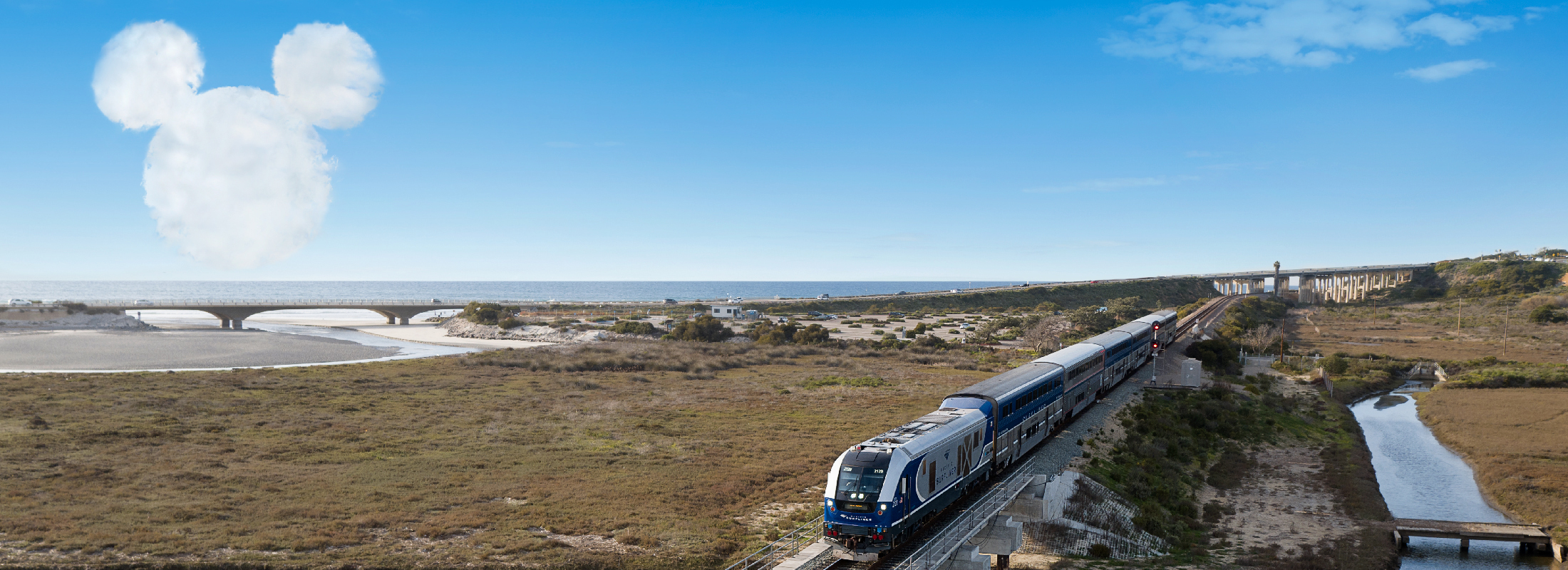 El tren Pacific Surfliner con un gráfico de una nube con la forma de Mickey Mouse, el personaje de Disney, superpuesto en el fondo