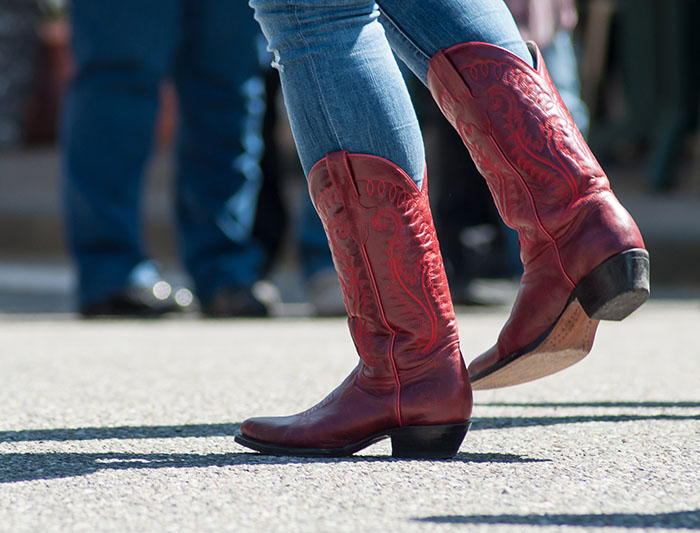 户外乡村演出中穿着红色美式皮靴的女性双腿特写