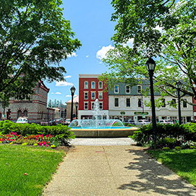 Blue skies and clouds float overhead a fountain and buildings in Pittsfield Massachusetts.