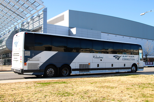 A bus is parked in front of a transportation center.